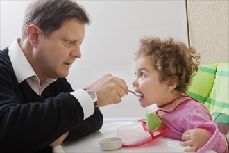 Father feeding his daughter