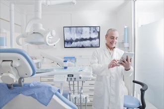 Dentist using digital tablet in dentist's surgery