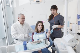 Patient smiling at mirror in dentist's surgery