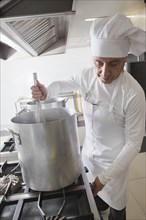 Chef using whisk in pot