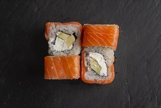 Salmon sushi on black surface