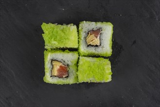 Green fish roe sushi on black surface