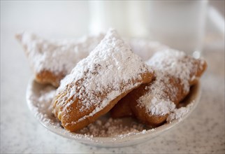 Beignets with powdered sugar on plate