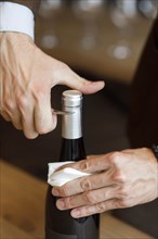 Hands of man opening bottle of wine