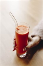 Hand of woman holding carrot juice