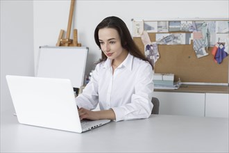 Fashion designer working at laptop
