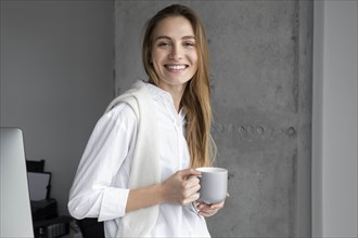 Smiling businesswoman with coffee cup