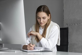 Businesswoman writing in notebook