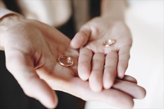 Hands of young couple holding wedding rings