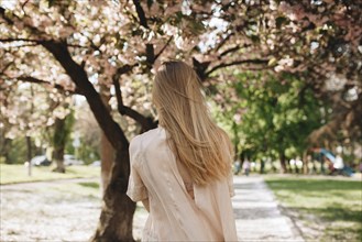 Blond haired woman by blossoming trees