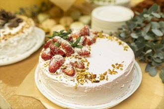Cake topped with strawberries and pistachios
