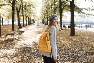 Young woman with yellow backpack in park in Berlin, Germany
