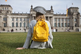 Young woman sitting in park by Reichstag in Berlin, Germany