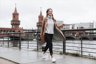Young woman walking by river in Berlin, Germany