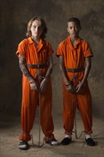 Boys in prisoner jumpsuits and handcuffs