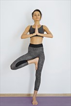 Woman standing on one leg practicing yoga