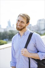 Smiling man wearing a striped shirt and backpack