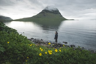 Woman walking by Kirkjufell in Iceland