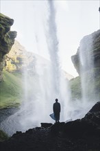 Silhouette of man behind Kvernufoss waterfall in Iceland