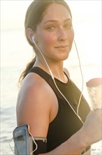 Woman wearing headphones holding water bottle