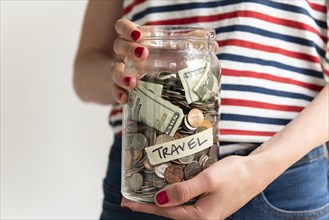 Woman holding travel savings jar