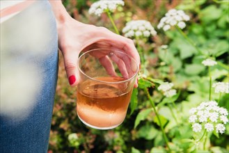 Woman holding glass of rose wine in garden