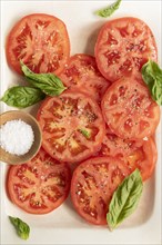 Sliced tomatoes with basil and salt