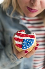 Woman holding American flag cupcake