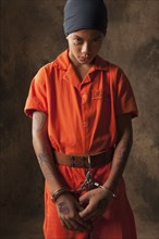 Boy in prisoner jumpsuit and handcuffs