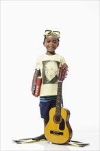 Boy wearing Einstein t-shirt and scuba mask holding guitar and books
