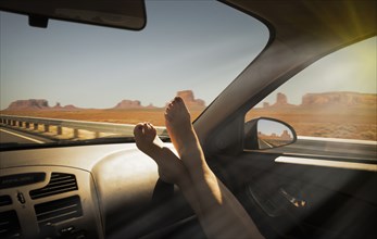 Woman's barefeet on dashboard in Monument Valley Navajo Tribal Park, USA