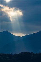 Sunbeams through clouds over mountains in Lombardy, Italy