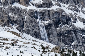 Snow falling down mountain cliff in Dolomites, Italy