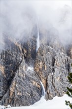 Snow falling down cliff in Dolomites, Italy