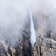 Snow falling down cliff in Dolomites, Italy