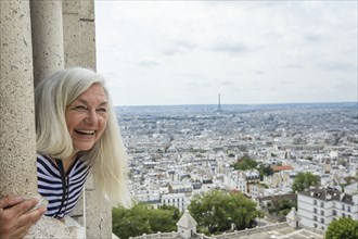 Smiling woman by cityscape from Sacre Coeur in Paris, France