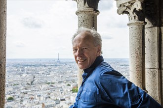 Smiling man by cityscape from Sacre Coeur in Paris, France