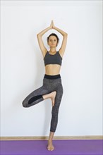 Woman standing on one leg practicing yoga