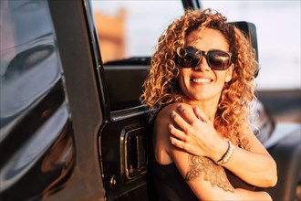 Smiling woman wearing sunglasses with arm tattoo