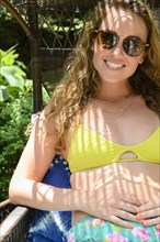 Smiling young woman wearing sunglasses and bikini