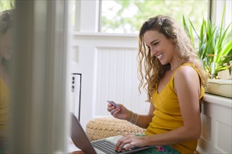 Smiling young woman online shopping