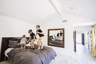 Children jumping on bed