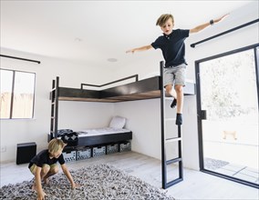 Boy jumping off bunk bed