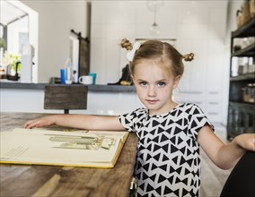 Girl at dining table with picture book