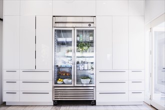 Glass refrigerator in modern kitchen