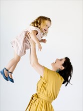 Mother holding her daughter aloft