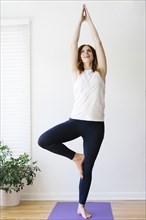Smiling mid adult woman practicing yoga