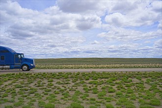 Blue truck on rural highway in Wyoming