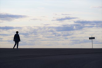 Silhouette of woman walking at sunset