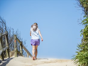 Rear view of woman walking on boardwalk